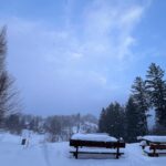 Widok na ławki przysypane grubą warstwą śniegu.